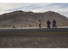 Central American migrants from Honduras, part of the Central American migrant caravan, walk along the highway that connects Mexicali with Tijuana, on the outskirts of Mexicali, Mexico, Monday, Nov. 19, 2018. The United States closed off northbound traffic for several hours at the busiest border crossing with Mexico to install new security barriers on Monday, a day after hundreds of Tijuana residents protested against the presence of thousands of Central American migrants.