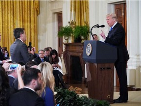 In this file photo taken on November 7, 2018 US President Donald Trump (R) gets into a heated exchange with CNN chief White House correspondent Jim Acosta (C) as NBC correspondent Peter Alexander (L) looks on during a post-election press conference in the East Room of the White House in Washington, DC. - CNN sued Donald Trump's administration November 13, 2018, alleging the White House violated journalist Jim Acosta's rights under the constitution by revoking his press credentials following a heated exchange with the US president.
