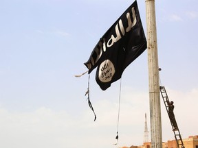 In this file photo taken on April 30, 2017 a member of the U.S.-backed Syrian Democratic Forces (SDF) removes an ISIL flag in the town of Tabqa, about 55 kilometres west of Raqa, as they advance in their battle for the group's de facto capital.