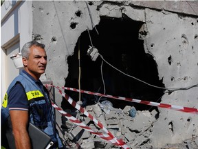 An Israeli man inspects a house damaged by a rocket fired from the Gaza Strip, in the southern Israeli town of Ashkelon, on November 13, 2018.