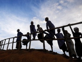 Young Rohingya refugees gather next to a bamboo railing while looking at a road below at Kutupalong refugee camp in Ukhia, in Bangladesh on November 14, 2018.