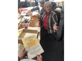 This Nov. 23, 2018 photo shows Alaska State Review Board ballot examiner Stuart Sliter reacting when a loose ballot from a tied state House race is found without an envelope in Juneau, Alaska. Officials are investigating the origin of the ballot and will decide by Friday, Nov. 30, whether to count it during a recount of the Fairbanks House District 1 race.