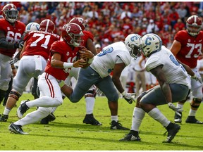 Alabama quarterback Tua Tagovailoa (13) carries the ball as he tries to get around Citadel linebacker Willie Eubanks III (9) during the second half of an NCAA college football game, Saturday, Nov. 17, 2018, in Tuscaloosa, Ala.