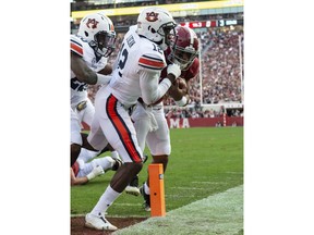 Alabama quarterback Tua Tagovailoa (13) pushes Auburn defensive back Jamel Dean (12) past the pylon for the game's first touchdown during the first half of an NCAA college football game, Saturday, Nov. 24, 2018, in Tuscaloosa, Ala.