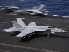 An F/A-18 Super Hornet fighter jet lands on the deck of the U.S. Navy USS Ronald Reagan in the South China Sea, Tuesday, Nov. 20, 2018.