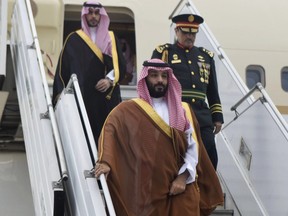 In this photo provided by the G20 Argentina press office, Saudi Arabia's Crown Prince Mohammed bin Salman deplanes at the airport in Buenos Aires, Argentina, Wednesday, Nov. 28, 2018. The prince, who will attend the two-day G20 Summit on Friday and Saturday, was taken to the Saudi embassy in Buenos Aires which is being guarded by dozens of police officers.