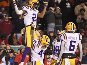 LSU receiver Justin Jefferson (2) celebrates with teammates Tory Carter (44) Foster Moreau (18) and Terrace Marshall Jr. (6) after scoring a touchdown against Arkansas during the first half of an NCAA college football game, Saturday, Nov. 10, 2018, in Fayetteville, Ark.