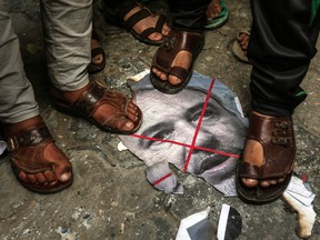 Palestinians step on a singed image of Israeli Defence Minister Avigdor Lieberman in Gaza on November 14, 2018, after Lieberman announced his resignation over a Gaza ceasefire deal.