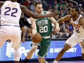 Boston Celtics forward Gordon Hayward (20) passes the ball as Phoenix Suns center Deandre Ayton (22) and forward TJ Warren (12) defend during the first half of an NBA basketball game Thursday, Nov. 8, 2018, in Phoenix.