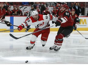 Carolina Hurricanes left wing Jordan Martinook (48) battles for the puck with Arizona Coyotes defenseman Jason Demers during the first period of an NHL hockey game Friday, Nov. 2, 2018, in Glendale, Ariz.