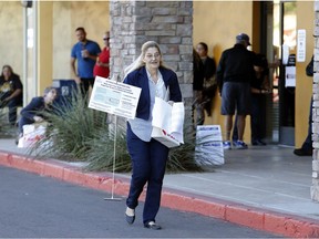 A volunteer moves supplies to a relocated polling station, Tuesday, Nov. 6, 2018 in Chandler, Ariz. The new polling station opened four hours late after the original location did not open due to the buildings' foreclosure overnight.