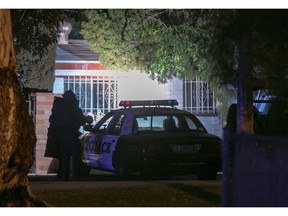 In this Thursday, Nov. 29, 2018 photo, a Tucson Police Department Officer stands stands outside the house where a suspect is holed up following a shooting in Tucson, Ariz. A deputy U.S. marshal serving a felony arrest warrant was shot and killed outside the Tucson house.  The suspect was arrested after an hour-long standoff at the home.