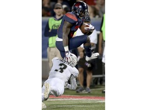 Arizona running back J.J. Taylor (21) tries to jump out of the arms of Colorado defensive back Derrion Rakestraw (3) during the first quarter of an NCAA college football game Friday, Nov. 2, 2018, in Tucson, Ariz.