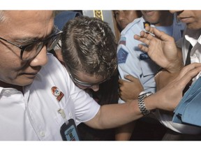 Australian Renae Lawrence, center, is escorted as she leaves Bangli prison in Bali, Indonesia, Wednesday, Nov. 21, 2018.  Lawrence Indonesia has freed an Australian woman who served nearly 14 years in prison for smuggling heroin into the tourist island of Bali.