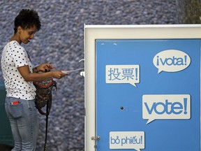 In this Aug. 7, 2018, file photo, voter Yordanos Bayru places her ballot into a drop box in Seattle.
