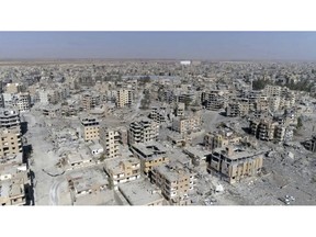 FILE - In this Thursday, Oct. 19, 2017, file photo, an image made from drone video shows damaged buildings in Raqqa, Syria. The rights group Amnesty International is enlisting the help of thousands of online activists to expand its investigation into the U.S-led campaign against Islamic State militants that ended the group's presence in the Syrian city of Raqqa but left it in utter devastation.