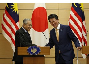Malaysia's Prime Minister Mahathir Mohamad exchanges smiles with Japan's Prime Minister Shinzo Abe at the end of their joint news conference at Abe's official residence in Tokyo, Tuesday, Nov. 6, 2018.
