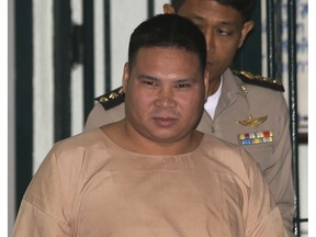 FILE - In this Thursday, March 3, 2016, file photo, Vivat Yodprasit, the "Popcorn Gunman," is escorted by Thai correctional officers while arriving at Criminal court in Bangkok, Thailand. Thailand's Supreme Court has restored the 37-year prison term given to Vivat after he was convicted of shooting four people during a 2014 political melee.