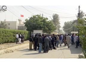 Security officials gather outside the compound of the Chinese Consulate following an attack, Friday, Nov. 23, 2018, in Karachi, Pakistan,. Gunmen have stormed the Chinese Consulate in Pakistan's southern port city of Karachi, triggering an intense shootout during which two police officers and all three assailants were killed. (AP Photo)