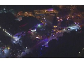In this image made from aerial video, police vehicles line a road in the vicinity of a shooting in Thousand Oaks, California, early Thursday, Nov. 8, 2018.  Authorities say there were multiple injuries _ including one officer _ after a man opened fire in Southern California bar late Wednesday. (KABC via AP)