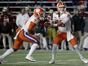 Clemson quarterback Trevor Lawrence, right, hands off to running back Travis Etienne during the first half of an NCAA college football game against Boston College, Saturday, Nov. 10, 2018, in Boston.