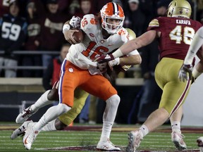 Clemson quarterback Trevor Lawrence (16) is dragged down by a Boston College defender during the first half of an NCAA college football game Saturday, Nov. 10, 2018, in Boston.