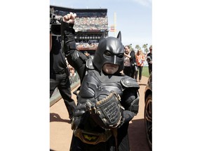 In this file photo from Tuesday, April 8, 2014, Miles Scott, dressed as Batkid, gestures after throwing the ceremonial first pitch before a baseball game between the San Francisco Giants and the Arizona Diamondbacks in San Francisco. On the five-year anniversary of then-5-year-old Miles Scott capturing the hearts of millions by saving the day in San Francisco as Batkid, his Make-A-Wish Foundation dream accomplished at last, the fifth-grader is thriving.