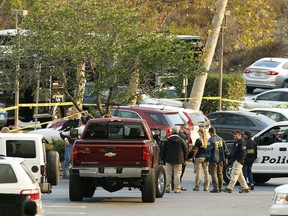 FBI investigators join law enforcement as they work near the scene of Wednesday's shooting in Thousand Oaks, Calif., Friday, Nov. 9, 2018. Investigators continue to work to figure out why an ex-Marine opened fire Wednesday evening inside a country music bar, killing multiple people.
