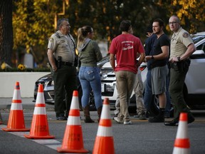 Thousand Oaks residents await to claim their vehicles as FBI agents verify vehicle registrations of autos parked in the lot of the Borderline Bar & Grill bar in Thousand Oaks, Calif., Friday, Nov. 9, 2018. The gunman who killed 12 people at the country music bar in Southern California went on social media during the attack and posted about his mental state and whether people would believe he was sane, a law enforcement official said Friday.