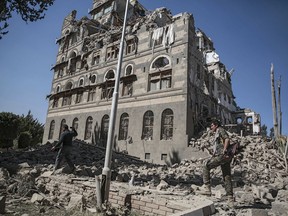 FILE - In this Dec. 6, 2017 file photo, Houthi Shiite rebels inspect the rubble of the Republican Palace that was destroyed by Saudi-led airstrikes, in Sanaa, Yemen. Airstrikes by Saudi Arabia and its allies in Yemen are on a pace to kill more civilians in 2018 than last year despite US claims that the coalition is working to prevent such bloodshed, a database tracking violence shows. The war, nearly four years old, may have killed as many as 80,000 people, according to the figures.