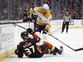 Anaheim Ducks' Nick Ritchie, bottom, falls to the ice after colliding with Nashville Predators' Craig Smith during the first period of an NHL hockey game Monday, Nov. 12, 2018, in Anaheim, Calif.