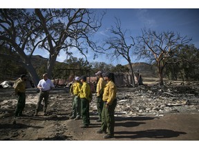 U.S. Secretary of the Interior Ryan Zinke, second from left, talks to firefighters while visiting decimated Paramount Ranch Thursday, Nov. 15, 2018, in Agoura Hills, Calif. The landmark film location burned to the ground by the Woolsey Fire.