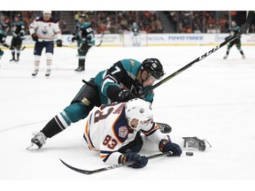 Edmonton Oilers' Matt Benning, bottom, falls to the ice while fighting for the puck with Anaheim Ducks' Nick Ritchie during the second period of an NHL hockey game Friday, Nov. 23, 2018, in Anaheim, Calif.