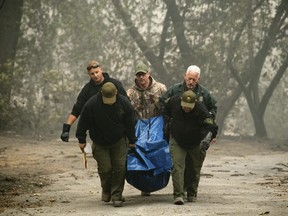 In this Nov. 10, 2018, file photo, sheriff's deputies recover the remains of a victim of the Camp Fire in Paradise, Calif.