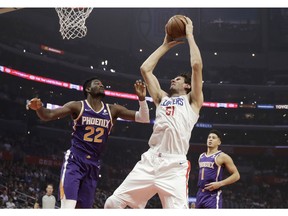 Los Angeles Clippers' Boban Marjanovic (51) grabs a rebound next to Phoenix Suns' Deandre Ayton (22) during the first half of an NBA basketball game Wednesday, Nov. 28, 2018, in Los Angeles.
