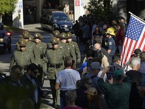 The body of Ventura County Sheriff's Department Sgt. Ron Helus is transported from the Los Robles Regional Medical Center Thursday, Nov. 8, 2018, in Thousand Oaks, Calif., after a gunman opened fire Wednesday inside a country music bar killing multiple people including Helus.