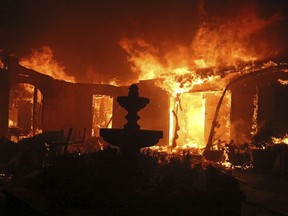 A Spanish-style home is consumed by flames on Dume Drive in the Point Dume area of Malibu, Calif., Friday, Nov. 9, 2018.