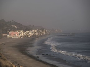 Thick smoke envelops the Malibu Colony along the pacific coast in Malibu, Calif. on Sunday Nov. 11, 2018. Strong Santa Ana winds have returned to Southern California, fanning a huge wildfire that has scorched a string of communities west of Los Angeles. A one-day lull in the dry, northeasterly winds ended Sunday morning and authorities warn that the gusts will continue through Tuesday.