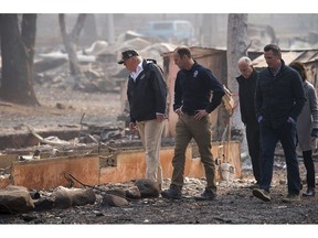 President Donald Trump,  from left, FEMA Administrator Brock Long, California Gov. Jerry Brown, Gov.-elect Gavin Newsom and Paradise Mayor Jody Jones tour the Skyway Villa Mobile Home and RV Park during Trump's visit of the Camp Fire in Paradise, Calif., Saturday, Nov. 17, 2018. Trump went to Northern California on Saturday to survey the devastation from the nation's deadliest wildfire in a century.