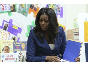 Former first lady Michelle Obama reads a book to school kids during a surprise appearance at Para Los Niños on Thursday, Nov. 15, 2018, in Los Angeles.