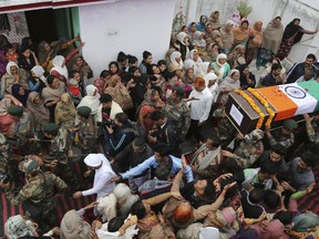 Family members grieve as the body an Indian Army soldier Varun Katal is being brought to his house before the cremation in village Mawa in Samba district, 62 kilometers (51 miles) from Jammu, India, Sunday, Nov. 11, 2018. An Indian soldier was killed when Pakistani soldiers fired at Indian positions along the highly militarized frontier in disputed Kashmir on Saturday, Indian military said.