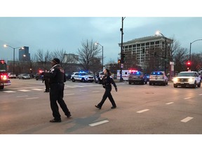 Chicago Police officers walk outside Mercy Hospital on the city's South Side where authorities say a shooting at the hospital has wounded multiple people, including a suspect and a police officer, Monday, Nov. 19, 2018, in Chicago.