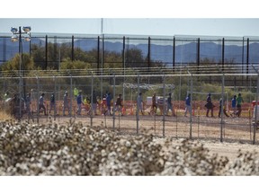 In this Nov. 15, 2018 photo provided by Ivan Pierre Aguirre, migrant teens are led in a line inside the Tornillo detention camp holding more than 2,300 migrant teens in Tornillo, Texas. The Trump administration announced in June 2018 that it would open the temporary shelter for up to 360 migrant children in this isolated corner of the Texas desert. Less than six months later, the facility has expanded into a detention camp holding thousands of teenagers - and it shows every sign of becoming more permanent.