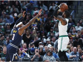 Boston Celtics guard Kyrie Irving, right, shoots a three-point basket over Denver Nuggets forward Torrey Craig in the first half of an NBA basketball game Monday, Nov. 5, 2018, in Denver.