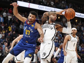 Brooklyn Nets guard D'Angelo Russell, right, pulls in a rebound as Denver Nuggets guard Jamal Murray covers in the first half of an NBA basketball game Friday, Nov. 9, 2018, in Denver.