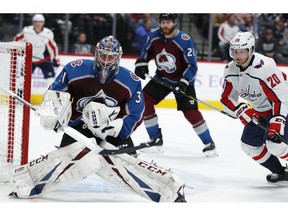 Colorado Avalanche goaltender Philipp Grubauer, left, makes a save as Washington Capitals center Lars Eller skates in from the side in the second period of an NHL hockey game Friday, Nov. 16, 2018, in Denver.