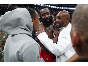 Houston Rockets guard James Harden, center, is hugged by Los Angeles Rams cornerback Aqib Talib, right, and wide receiver Robert Woods after the second half of an NBA basketball game against the Denver Nuggets, Tuesday, Nov. 13, 2018, in Denver. The Rockets won 109-99. The Rams are in Colorado to train for their game against the Kansas City Chiefs that was scheduled for Mexico City. Harden gave his jersey to Talib.