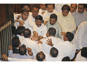 Sri Lankan Lawmakers fight in the parliament chamber in Colombo, Sri Lanka, Thursday, Nov. 15, 2018. Rival lawmakers exchanged blows in Sri Lanka's Parliament on Thursday as disputed Prime Minister Mahinda Rajapaksa claimed the speaker had no authority to remove him from office by voice vote.