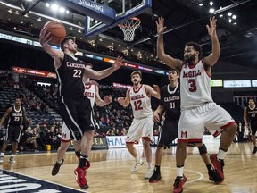 Carleton Ravens' Mitch Wood, left, looks to pass before going out of bounds in front of McGill Redmen's Noah Daoust, centre, and Dele Ogundokun in the bronze medal game of the U Sports men's basketball national championship in Halifax on Sunday, March 11, 2018.