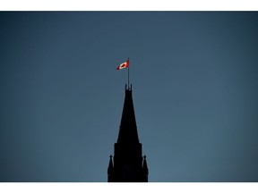 The Canadian Flag is illuminated by morning light atop the Peace Tower on Parliament Hill in Ottawa on Monday, Sept. 17, 2018. Canada is not properly protecting diplomats and staff who face security threats at Canadian missions abroad, including many in locations at high risk of terrorist attacks, violence and espionage, the federal auditor general says.
